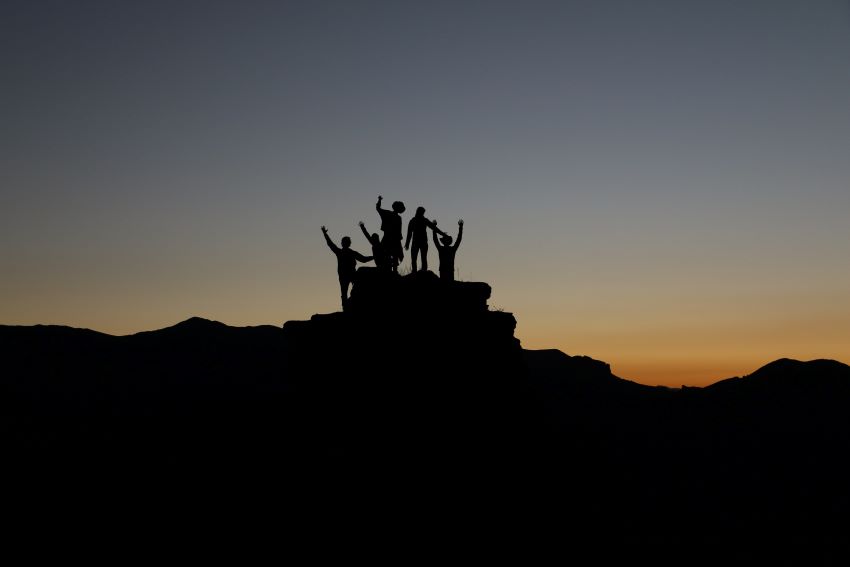 silhouette of people hiking during sunset