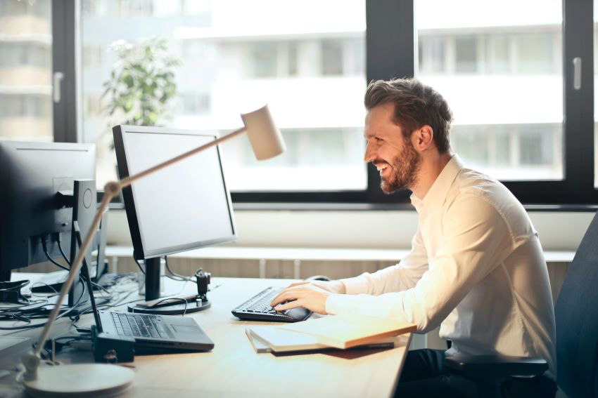 man looking at his computer laughing