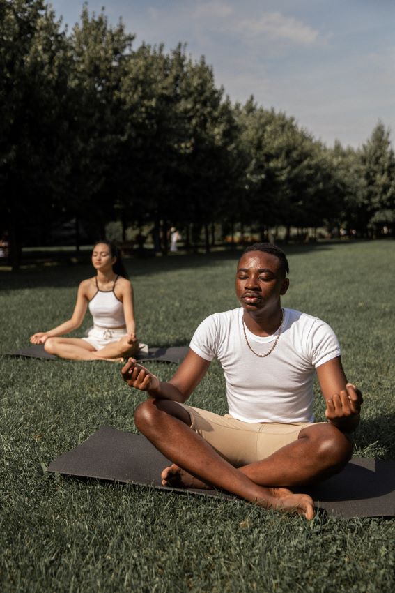 2 people doing yoga in the park