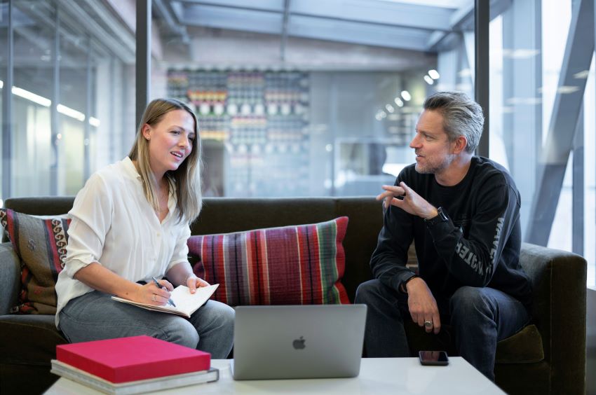 two people discussing over a laptop