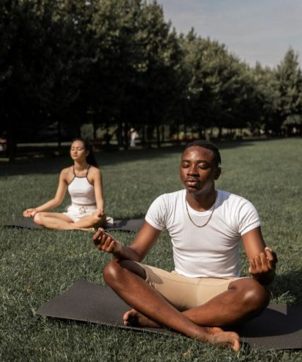 2 people doing yoga in the park