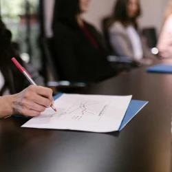 employee smiling and taking notes in a meeting