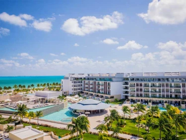 aerial view of Majestic Elegance Costa Mujeres with its pools and buildings and the beach