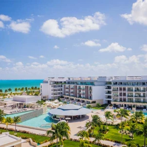 aerial view of Majestic Elegance Costa Mujeres with its pools and buildings and the beach
