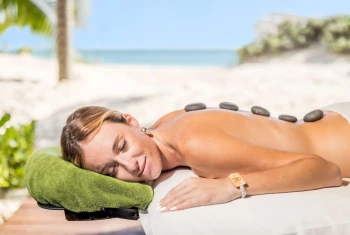woman enjoying a spa therapy on the beach at Majestic Mirage Costa Mujeres