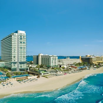 Aerial view of the modern high-rise Secrets The Vine Cancun resort on the white-sand beach.