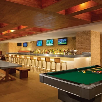 Half Time Sports Bar with a long bar, multiple TVs, a pool table, and communal wooden seating.