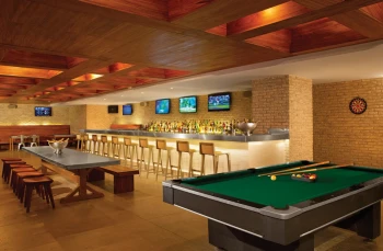 Half Time Sports Bar with a long bar, multiple TVs, a pool table, and communal wooden seating.