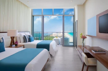 Preferred Club double room with bright floor-to-ceiling windows and a breathtaking ocean view balcony.