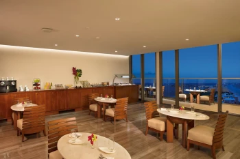 Preferred Club Lounge at sunset with floor-to-ceiling windows and a buffet display area.
