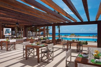 Sea Salt Grill, an open-air restaurant with wooden beams, overlooking the pool and Caribbean Sea.