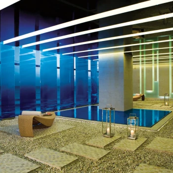 Modern and serene hydrotherapy area in the Secrets Spa with blue and yellow mood lighting.
